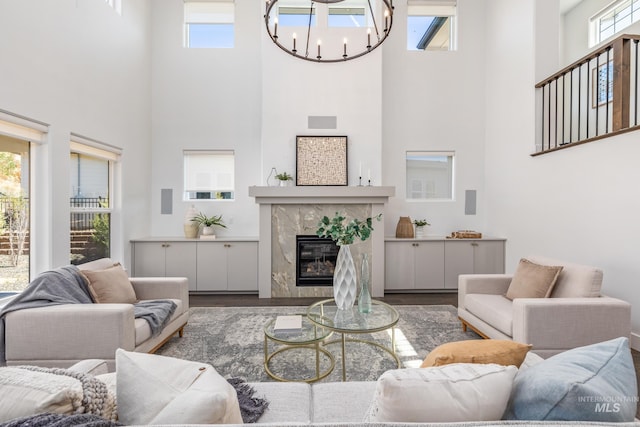 living room featuring a high ceiling, a high end fireplace, and a healthy amount of sunlight