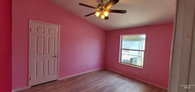 unfurnished room with visible vents, baseboards, ceiling fan, lofted ceiling, and light wood-style flooring