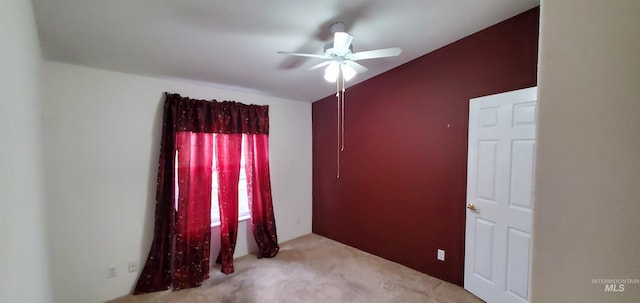 carpeted spare room with a ceiling fan