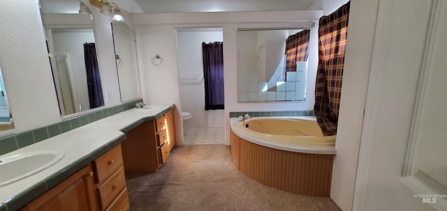 bathroom with toilet, vanity, and a garden tub