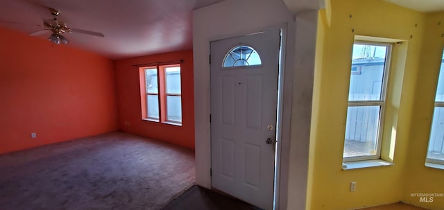 carpeted foyer entrance featuring a wealth of natural light and a ceiling fan