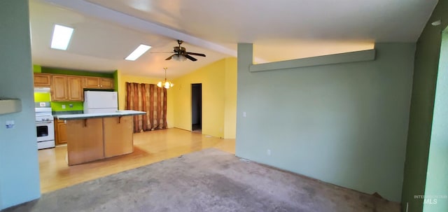 kitchen with lofted ceiling with skylight, a breakfast bar, ceiling fan with notable chandelier, white appliances, and a peninsula