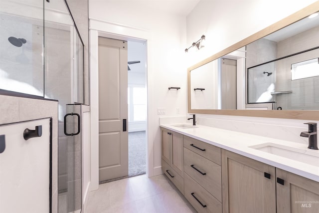 bathroom featuring tile patterned floors, a sink, a shower stall, and double vanity