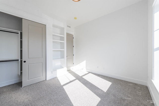 unfurnished bedroom with carpet floors, visible vents, and baseboards