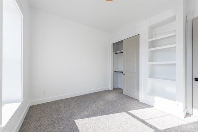 unfurnished bedroom with carpet floors, a closet, and baseboards