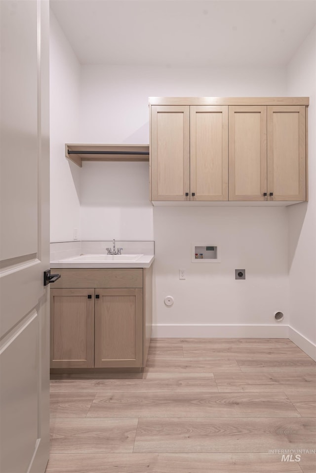 clothes washing area featuring cabinet space, hookup for a gas dryer, hookup for a washing machine, hookup for an electric dryer, and light wood-style floors