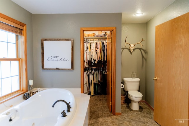 bathroom with tile patterned floors, a bathing tub, and toilet