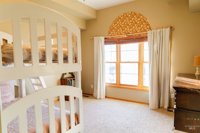 carpeted bedroom with a nursery area