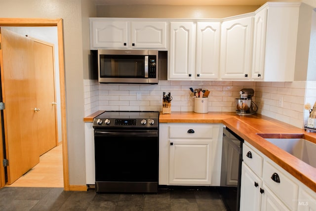 kitchen featuring wooden counters, white cabinets, and electric stove