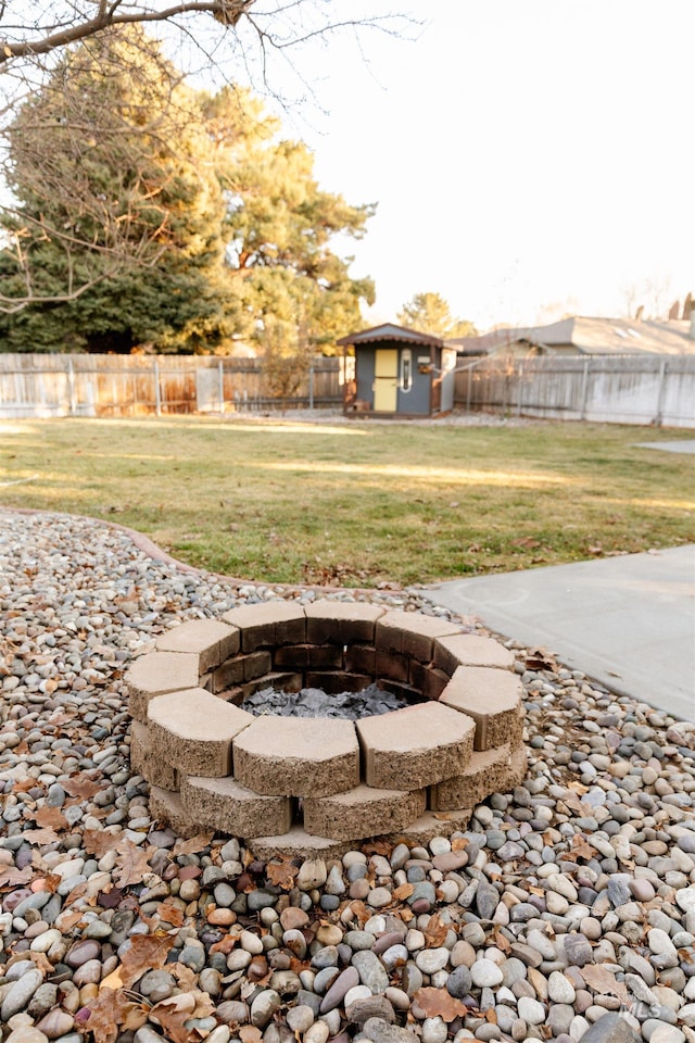 view of yard with a fire pit and an outdoor structure