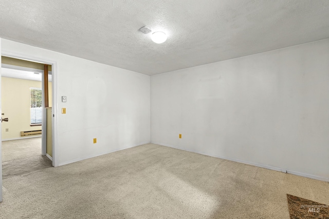 carpeted empty room with a baseboard radiator and a textured ceiling