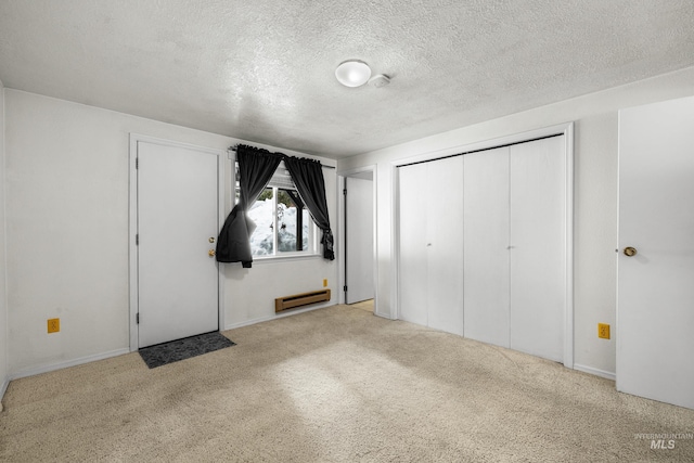 unfurnished bedroom featuring a textured ceiling, carpet floors, baseboard heating, and a closet