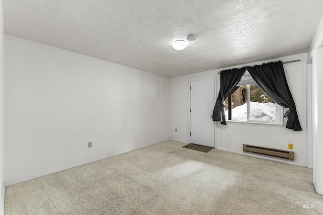 carpeted spare room with a baseboard heating unit and a textured ceiling