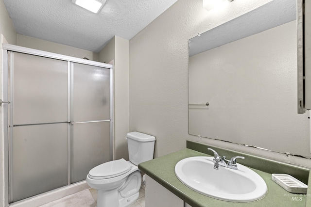 full bath featuring a textured wall, toilet, a textured ceiling, vanity, and a shower stall