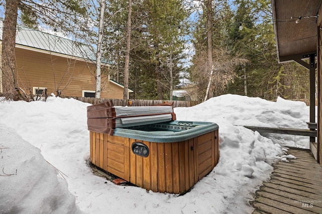 yard covered in snow featuring fence and a hot tub