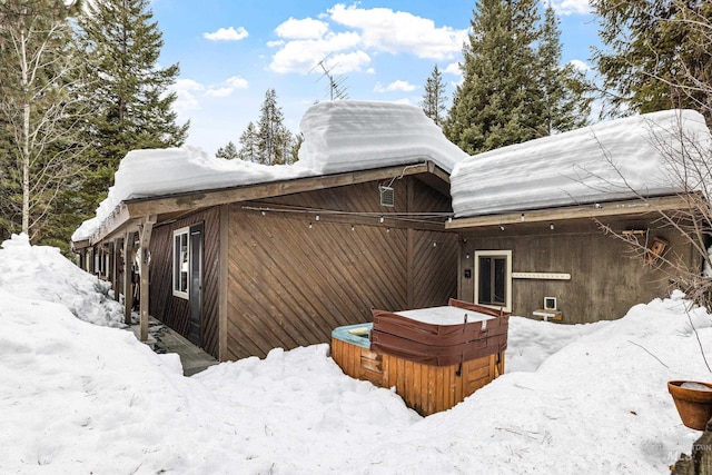 view of snowy exterior featuring a hot tub