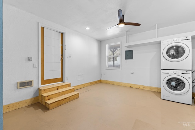 washroom featuring stacked washing maching and dryer, baseboards, visible vents, and laundry area