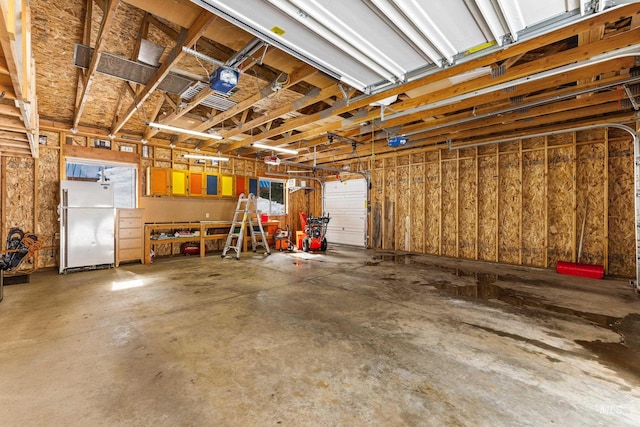 garage featuring freestanding refrigerator and a garage door opener