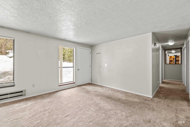 empty room with carpet, baseboards, a textured ceiling, and baseboard heating