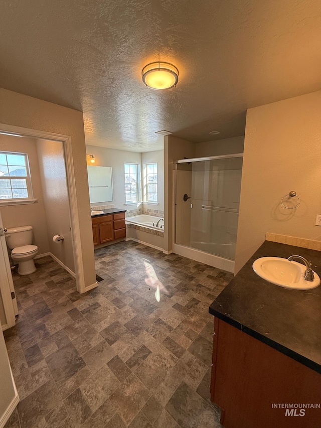 full bathroom with vanity, toilet, independent shower and bath, and a textured ceiling