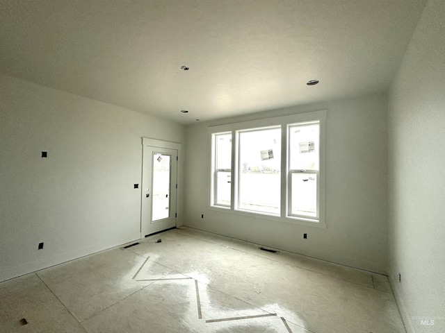 unfurnished room with visible vents