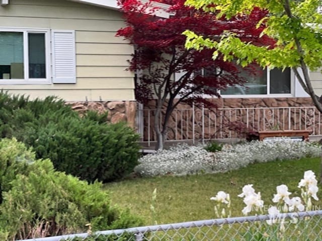view of home's exterior with stone siding and fence