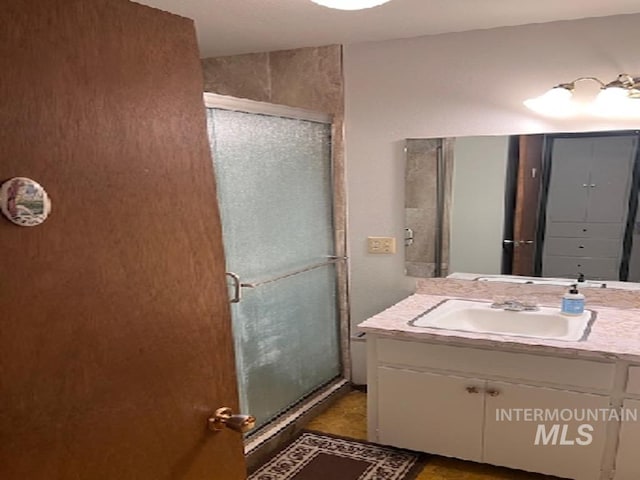 full bath with a shower stall and vanity