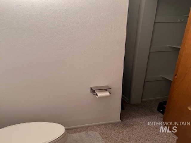 bathroom with toilet and baseboards