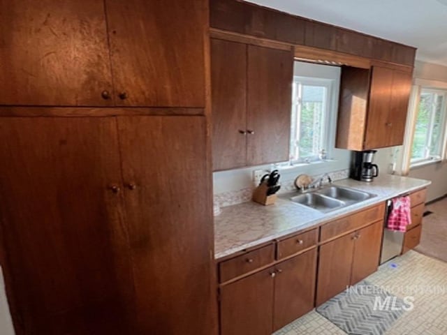 kitchen featuring light countertops, a sink, and brown cabinets