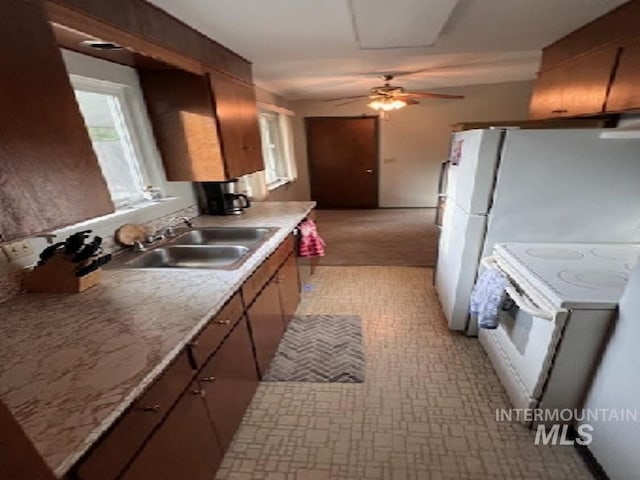 kitchen with white electric range, a sink, ceiling fan, light countertops, and light flooring