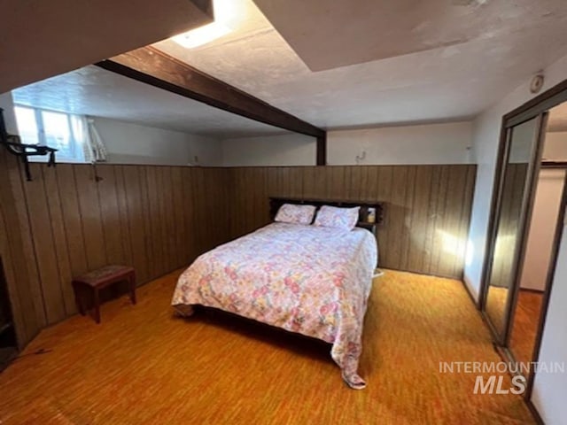 bedroom featuring wooden walls, carpet, and a wainscoted wall
