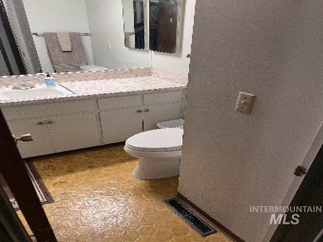 bathroom featuring toilet and vanity
