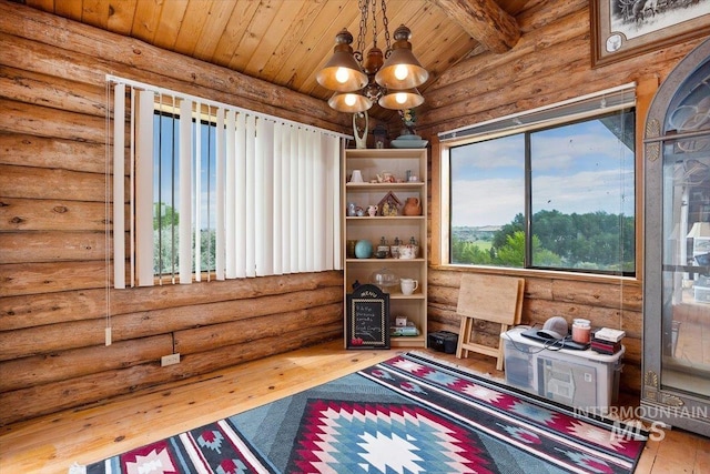 sitting room with wood ceiling, log walls, hardwood / wood-style flooring, an inviting chandelier, and vaulted ceiling with beams