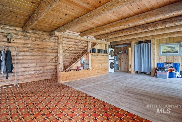 interior space with beamed ceiling, wood ceiling, stacked washer / dryer, and log walls