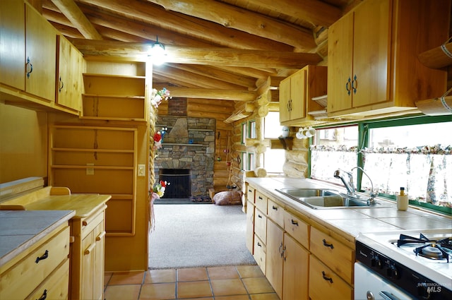 kitchen featuring a fireplace, beam ceiling, sink, light tile floors, and tile countertops