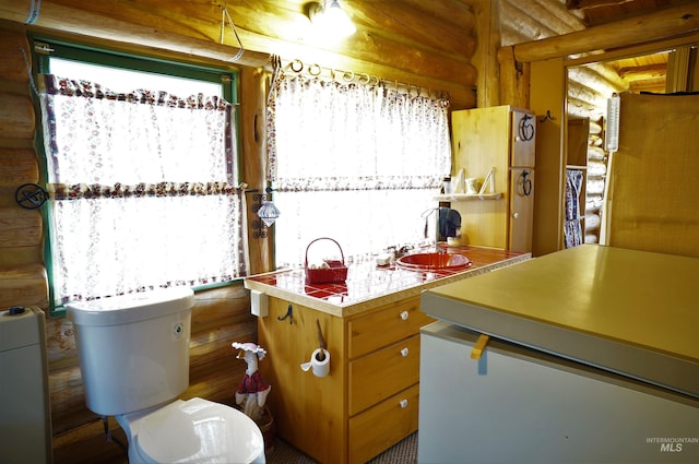 kitchen with plenty of natural light, tile countertops, and rustic walls