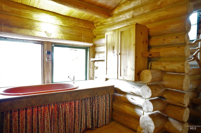 interior space featuring hardwood / wood-style flooring, log walls, wooden ceiling, and beam ceiling