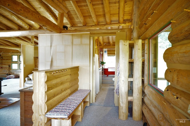 corridor featuring wood ceiling, rustic walls, light carpet, and beamed ceiling