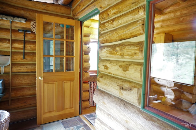 entryway with log walls and light tile floors