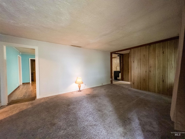 300 S Morgan Ave, New Meadows, ID 83654 - carpeted empty room featuring wooden walls and a textured ceiling