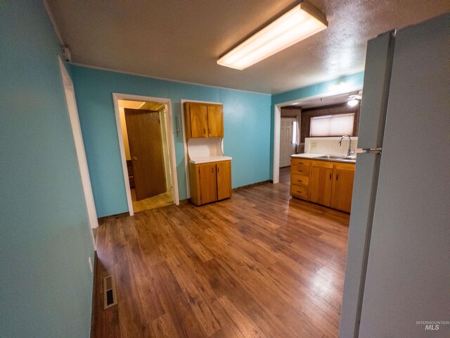 300 S Morgan Ave, New Meadows, ID 83654 - kitchen with freestanding refrigerator, light countertops, brown cabinetry, and wood finished floors