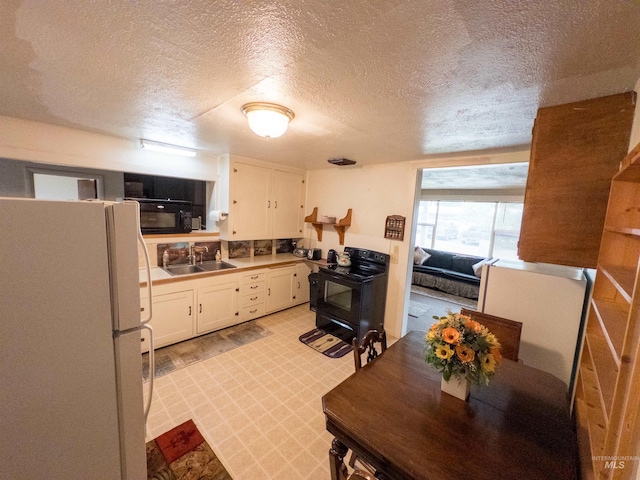 300 S Morgan Ave, New Meadows, ID 83654 - kitchen featuring black appliances, a textured ceiling, white cabinetry, and light countertops