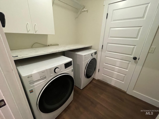 laundry area featuring cabinets, dark hardwood / wood-style floors, and washer and dryer