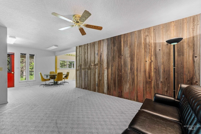 1718 Warren Wagon Rd, Mccall, ID 83638 - carpeted living area with wooden walls, a textured ceiling, and ceiling fan