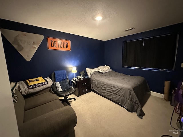 bedroom featuring a textured ceiling and carpet