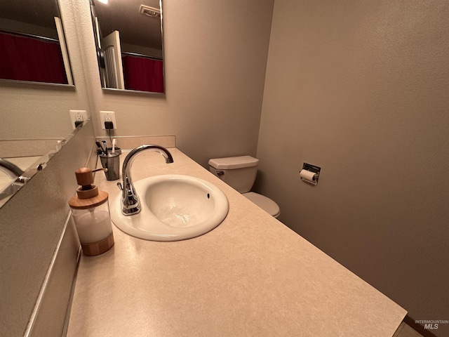 bathroom featuring vanity, toilet, and curtained shower