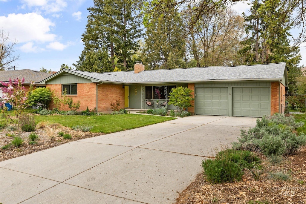 ranch-style home featuring brick siding, an attached garage, a chimney, and concrete driveway