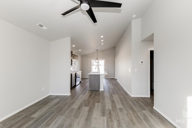 unfurnished living room with recessed lighting, wood finished floors, visible vents, baseboards, and vaulted ceiling