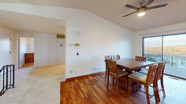 dining area featuring ceiling fan, vaulted ceiling, and light wood-type flooring