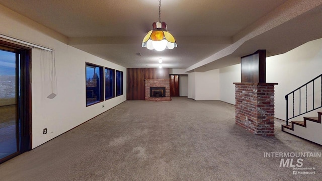 unfurnished living room with carpet floors, wooden walls, and beamed ceiling